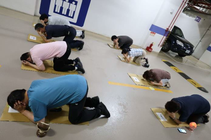 新北分署防空疏散避難防護團編組成員快速疏散，並按指示採蹲式手摀住眼睛耳朵標準避難姿勢，完成此次            預演活動。